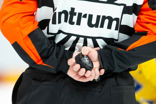 Referee holds the puck