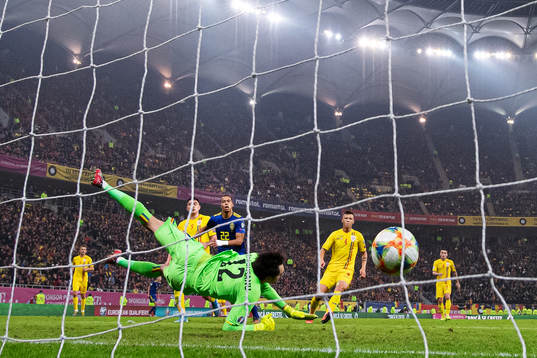 Robin Quaison of Sweden scores 0-2 behind goalkeeper
