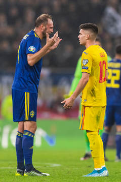 Andreas Granqvist of Sweden and Ianis Hagi of Romania in a