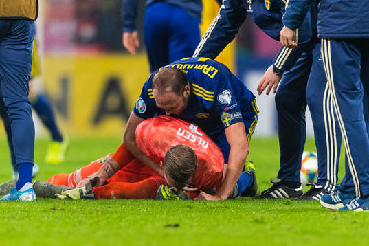 Andreas Granqvist and goalkeeper Robin Olsen of Sweden hug