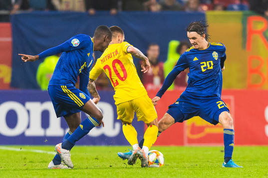Alexander Isak and Kristoffer Olsson of Sweden compete for