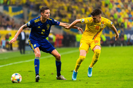 Mikael Lustig of Sweden and Ianis Hagi of Romania compete