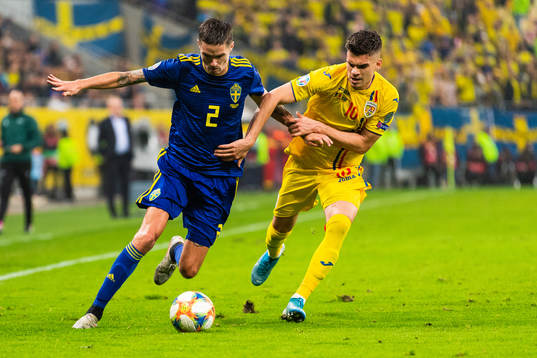 Mikael Lustig of Sweden and Ianis Hagi of Romania compete