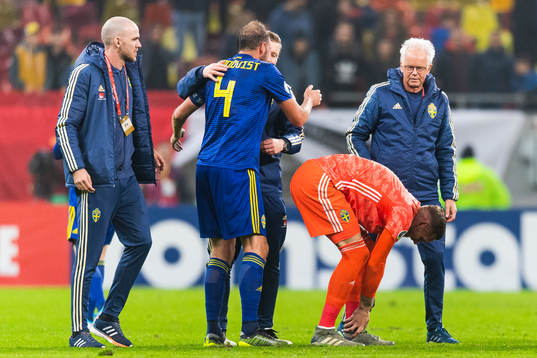 Medical staff attend to goalkeeper Robin Olsen of Sweden