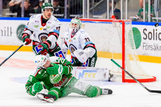 Rögles Anton Bengtsson  får pucken i ansiktet och har ont