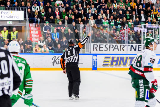 Domare Sören Persson pekar mot jumbotronen