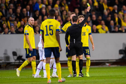 Mattias Svanberg of Sweden receives a yellow card from