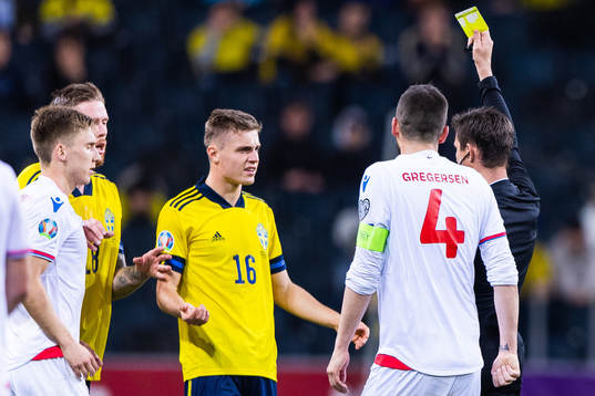 Mattias Svanberg of Sweden receives a yellow card from