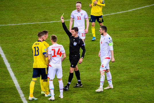 Mattias Svanberg of Sweden receives a yellow card from