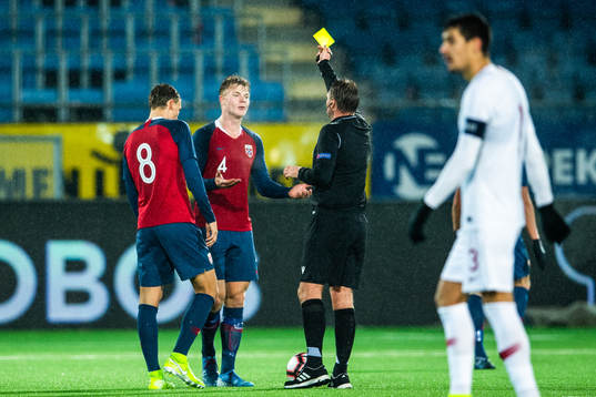 Ulrik Fredriksen of Norway receives a yellow card from