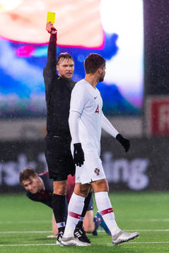 Referee Segei Lapochkin gives a yellow card to Diogo