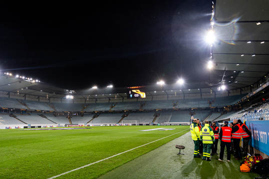 Medics and safety personnel are gathered next to the pitch