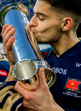 Ylldren Ibrahimaj of Viking kisses the trophy