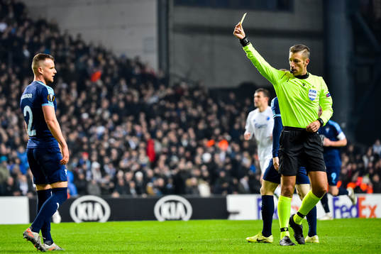 Eric Larsson of Malmö FF receives a yellow card from