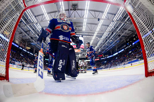 Växjös målvakt Viktor Fasth plockar en puck ur egna