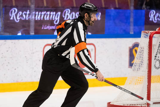 Domare Mikael Sjöqvist med klubba i handen