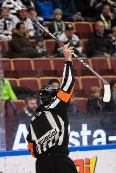 Domare Mikael Sjöqvist med klubba i handen vid avvaktande