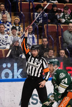 Domare Mikael Sjöqvist med klubba i handen vid avvaktande