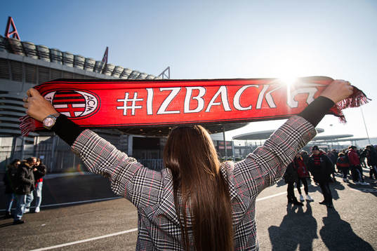 A supporter of mIlan pose with a Zlatan Ibrahimović scarf