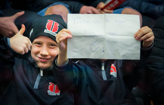 Två killar med Örebrotröjor håller upp en lapp om