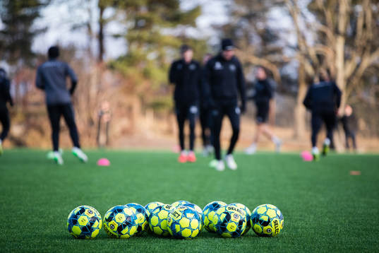 Fotbollar ligger på konstgräset