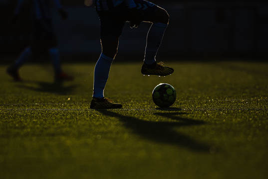 Siluett av en fotbollsspelare med boll