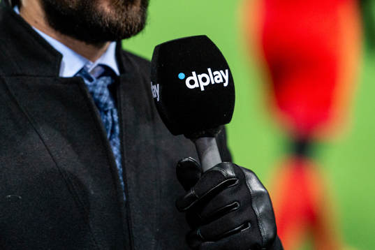 En reporter håller i en mikrofon med dplays logo på