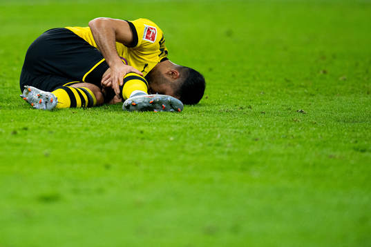 Emre Can of Borussia Dortmund lies down with an injury