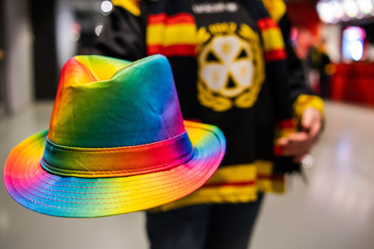 En Brynäs supporter håller en hatt i pridefärger