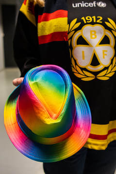 En Brynäs supporter håller en hatt i pridefärger