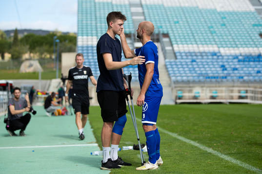 Emil Holm of IFK Göteborg with crutches gets a hug from