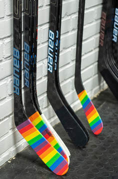 Hockeyklubbor tejpade med pridetejp