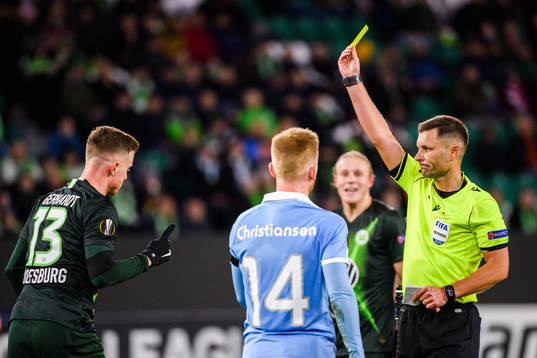 Yannick Gerhardt of Wolfsburg receives a yellow card