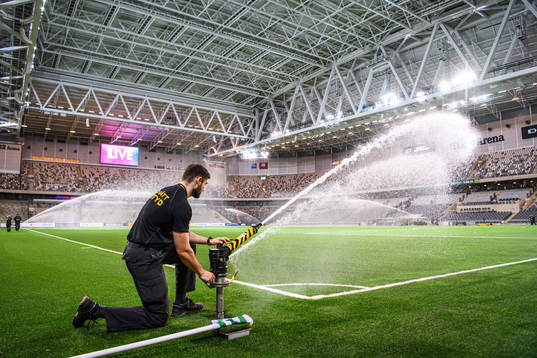 En matchvärd vattnar planen