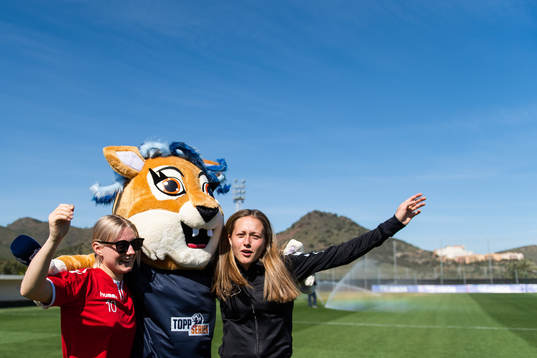 Runa Lillegård and Camilla Linberg of Lyn with the mascot
