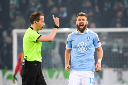 Referee William Sean Collum and Rasmus Jönsson of Malmö FF
