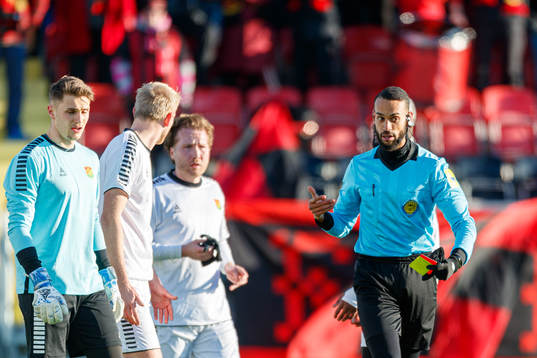 huvuddomare Farouk Nehdi med gult och rött kort framme