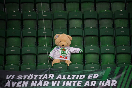 En nallebjörn i Rögle tröja sitter ensam på läktaren