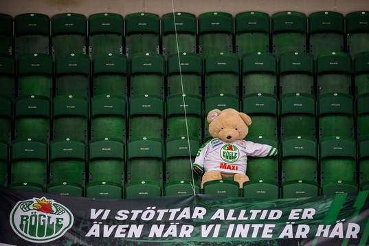 En nallebjörn i Rögle tröja sitter ensam på läktaren