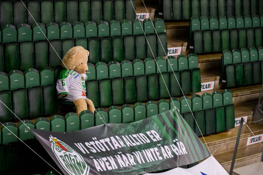 En nallebjörn i Rögle tröja sitter ensam på läktaren