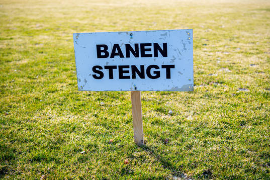 A sign states that the football field is closed as the