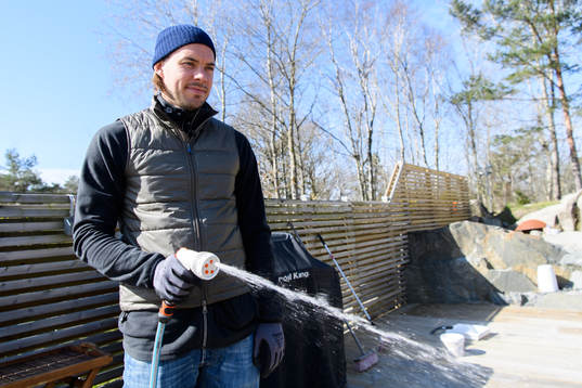 Danny Ervik spolar rent altanen i sitt hem