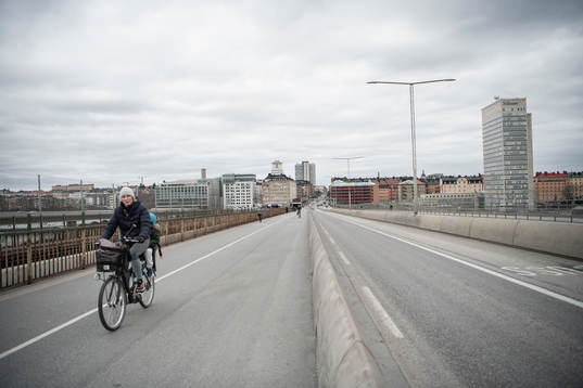 People bicycle at the Skanstull bridge as the coronavirus,