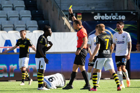 s Ebenezer Ofori får gult kort av domare Martin