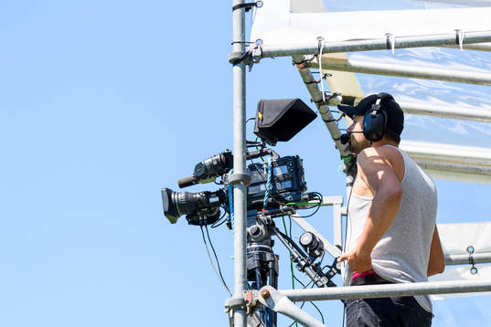 En tv-fotograf följer fotbollsmatchen i Division 1 södra