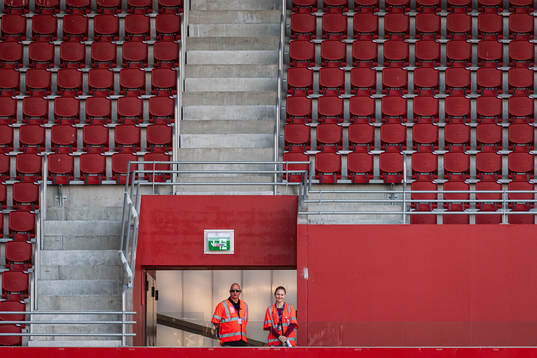Publikvärdar står på Olympias tomma läktare