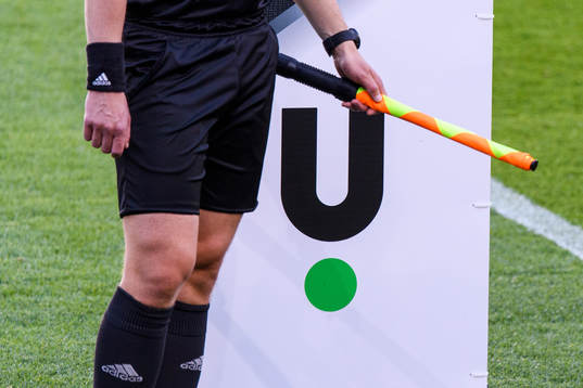 Unibets logotype bakom en linjedommare med flagga