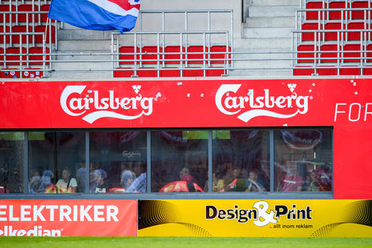 Besökare på en sportbar följer fotbollsmatchen i