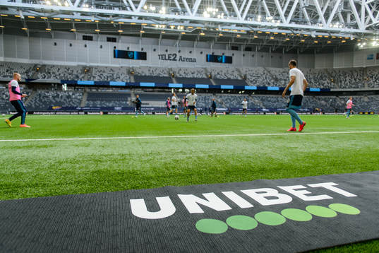 Djurgårdens spelare värmer upp framför en Unibet-logga