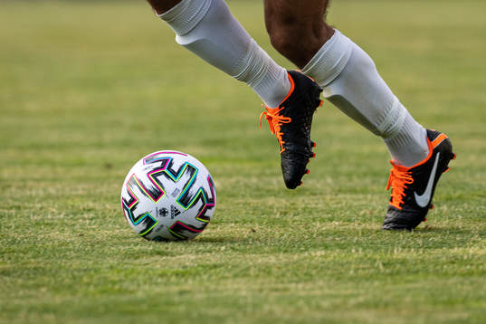 En fotbollsspelare springer med bollen